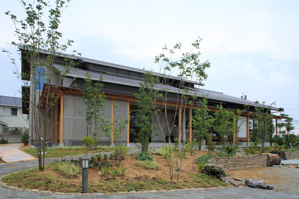 つし二階の平屋のような外観をイメージした和モダンの二階建て住宅、タイル貼りの外観に程よいデザインの奥行きを持つアルミ素材の格子は和をモダンに表現する奥行きのある設計