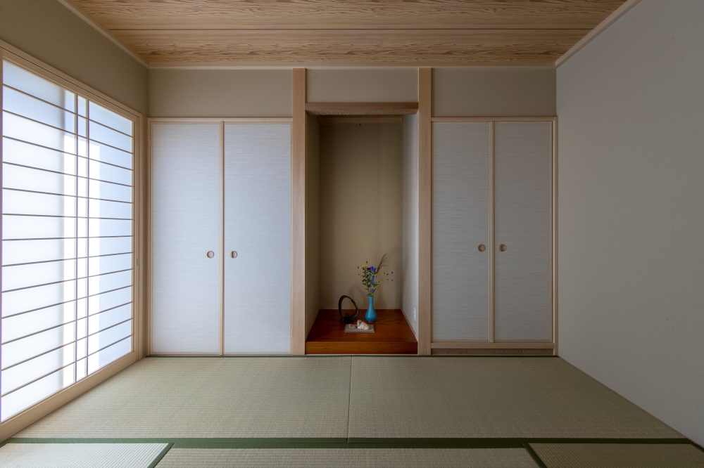 繊細な和の美意識と現代的な暮らしやすさを融合した、和モダン住宅の和室空間。やわらかな自然光を取り込む障子と、落ち着いた畳の質感、余白を活かした床の間設計が、静寂と上質感を演出している。白を基調とした襖と木の温もりが調和し、数寄屋の趣を感じさせる空間構成。客間としてだけでなく、日常のくつろぎや心を整える居場所としても機能する和室事例。和風住宅・和モダンの家・高級注文住宅・旅館のような家・畳のある暮らし・デザイナーズ住宅を検討している方に向けた、丁寧に設計された和空間。