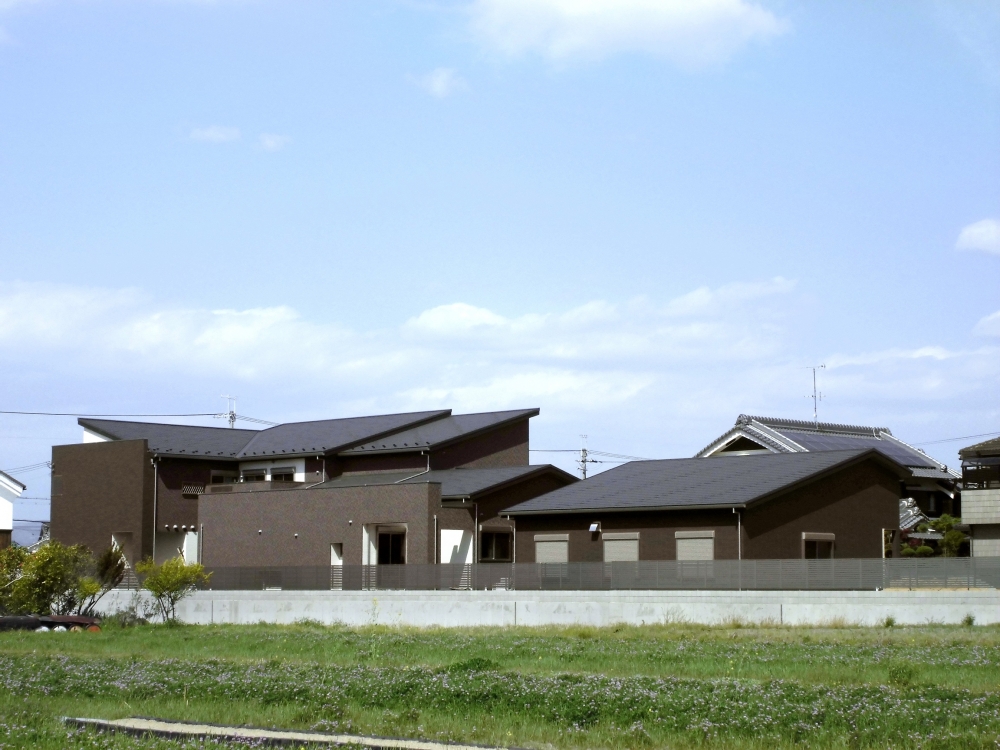 広がりある敷地に調和する和モダン住宅。水平ラインを意識した構成と落ち着いた外壁色により、周囲の風景に溶け込みながらも存在感を放つ設計。