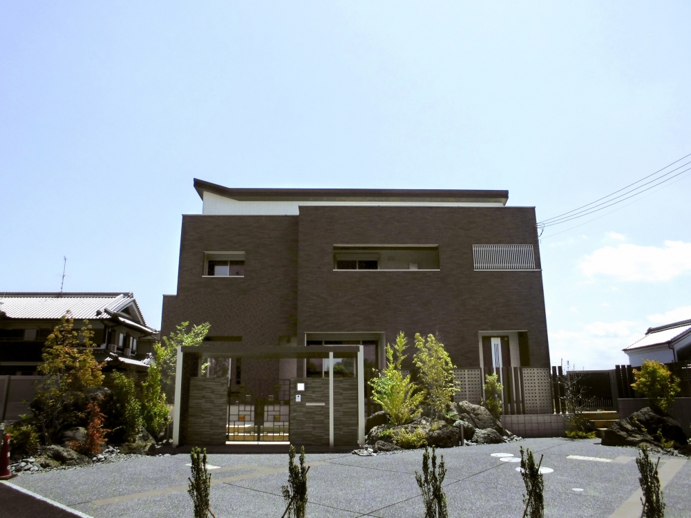 重厚感ある外壁と開口計画が印象的な和モダン住宅の正面外観。陰影を生む設計により、時間とともに表情が変わる住まい。