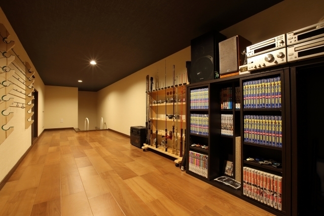 趣味の時間を深く楽しむために設計された和モダン住宅のDEN・趣味室。釣り道具やコレクション、本棚やオーディオ機器を美しく収納できる造作棚と広がりのある空間構成が特徴。落ち着いた照明と木質の床が心を整え、秘密基地のような没入感を演出。ホテルライクな上質さと個人の時間を大切にした住まいの一角。